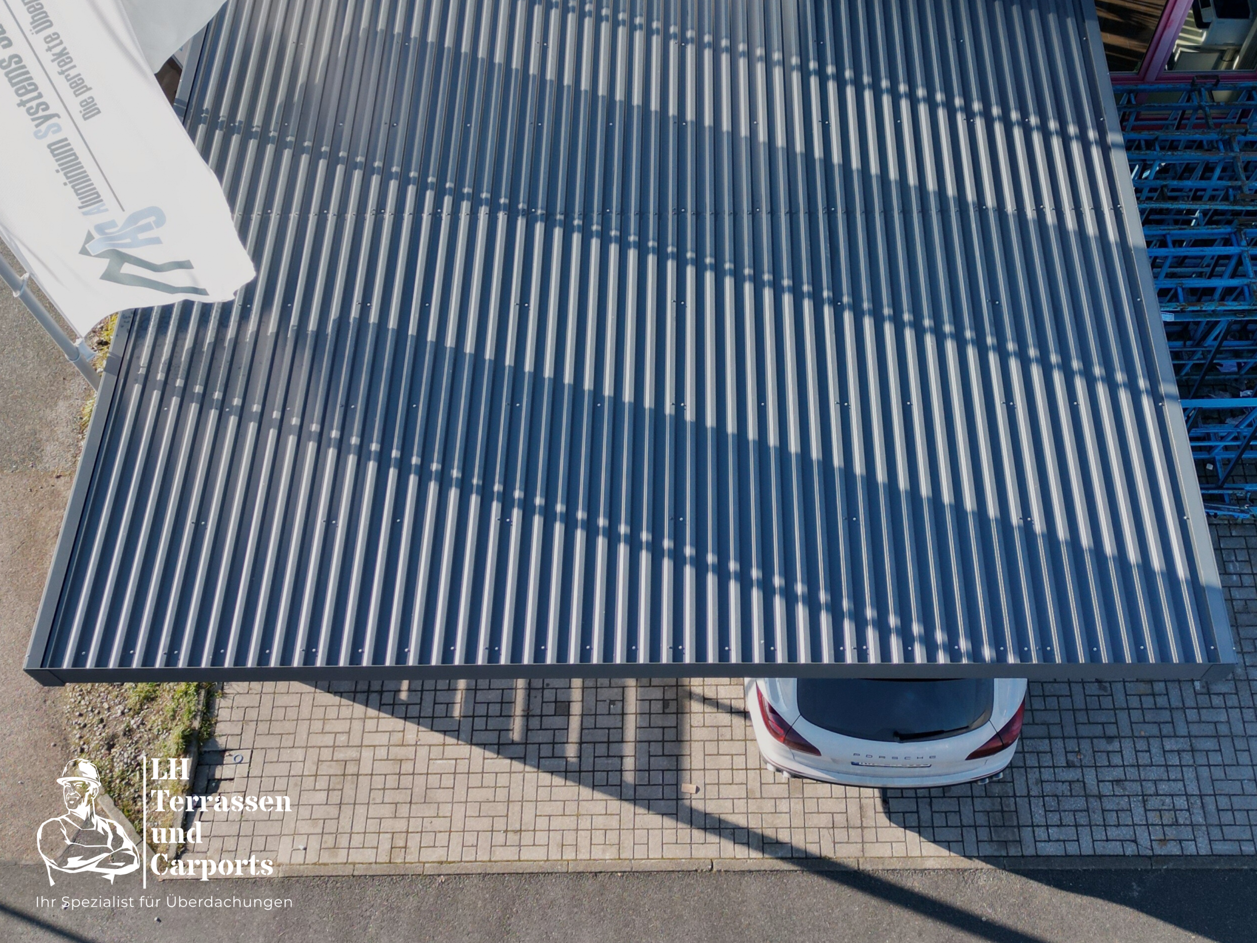 Ein Carport mit geparktem Auto direkt an der Straße in Bayern