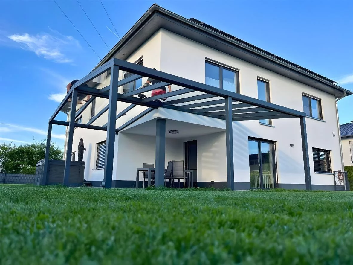 Ein modernes Haus mit Terrassendach aus Aluminium-Konstruktion und Glasdach