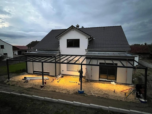 Montage einer Terrassenüberdachung an einem modernen Einfamilienhaus