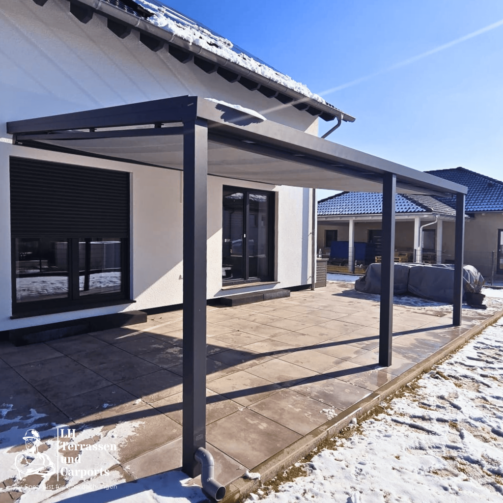 Terrassenüberdachung an einem modernen Einfamilienhaus im Winter.