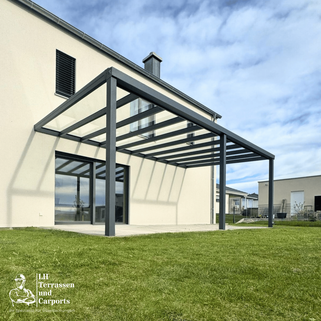 Eine Terrassenüberdachung mit Aluminiumkonstruktion und Glasdach an einem Einfamilienhaus.
